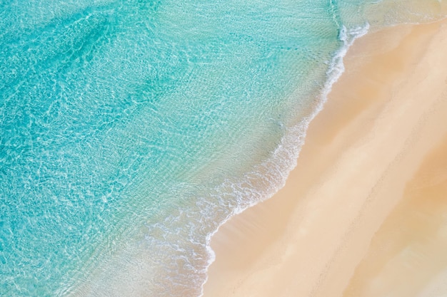 Summer seascape beautiful waves, blue sea water in sunny day. Top view from drone. Sea aerial view