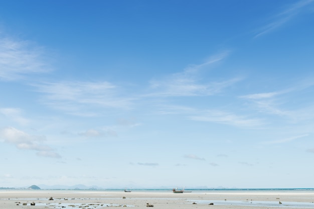 Summer seascape with green island and blue sky background