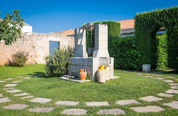 Summer season in Italy. Desing water well in an elegant garden.