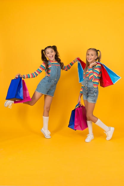 Summer shopping Buyer consumer concept Total sale Kids fashion Holiday purchase saving Home shopping Small girls with shopping bags Sales and discounts Happy children Little girls with gifts