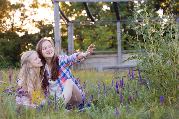 Summer - Smiling girls sisters have fun in a meadow