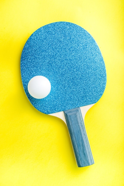 Summer sport activity concept. Bright ping pong tennis paddle  rackets with ball on trendy yellow background