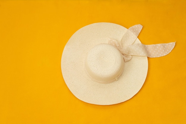 Summer straw hat on a yellow background