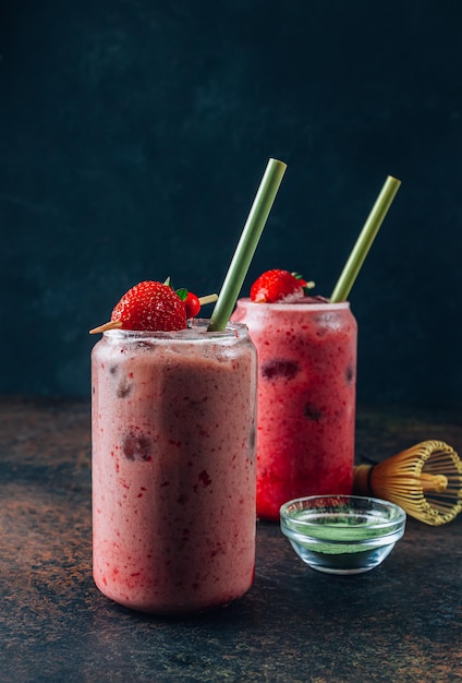 Summer strawberry matcha latte with ice in a glass cup