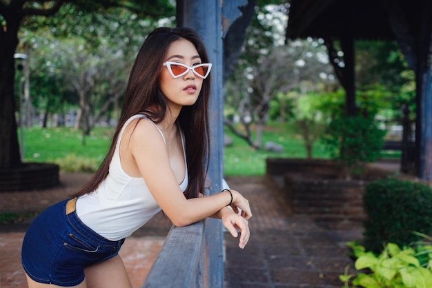 Summer sunny lifestyle portrait of young stylish hipster woman walking on the street wearing cute trendy outfit Young Asian women tourist traveler smiling in bangkok street fashion