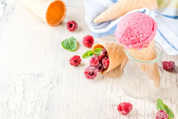 Summer sweet berries and desserts, various of ice cream flavor in cones pink (raspberry), vanilla and chocolate with mint on light concrete   