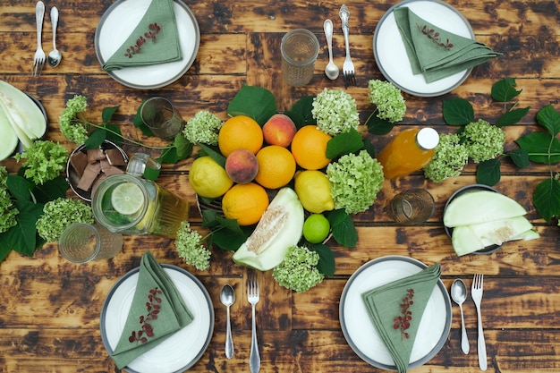 Summer table set Dining table decorated fresh flowers and fruits top view