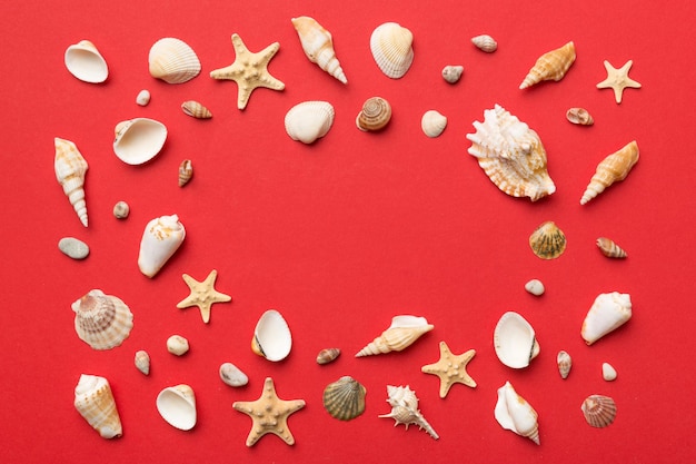 Summer time concept Flat lay composition with beautiful starfish and sea shells on colored table top view with copy space for text