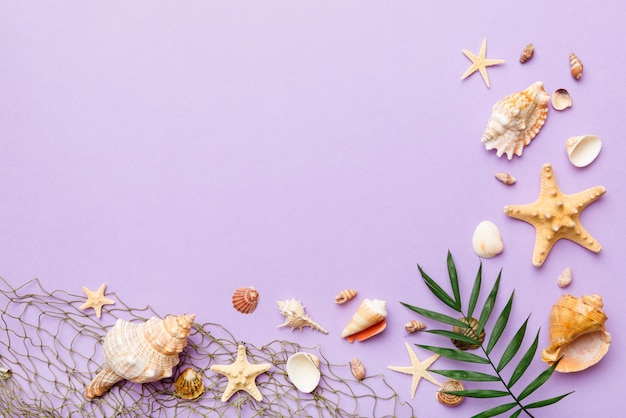 Summer time concept Flat lay composition with beautiful starfish and sea shells on colored table top view with copy space for text