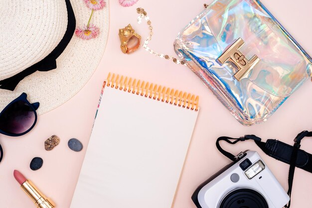 summer travel accessories camera hat glasses and a flat Notepad top view lay flat on a light background