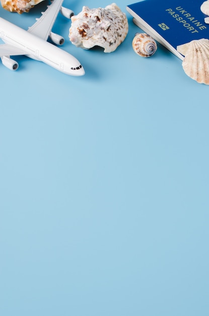 Summer travel concept. Decorative airplane, passports, hat and seashells.