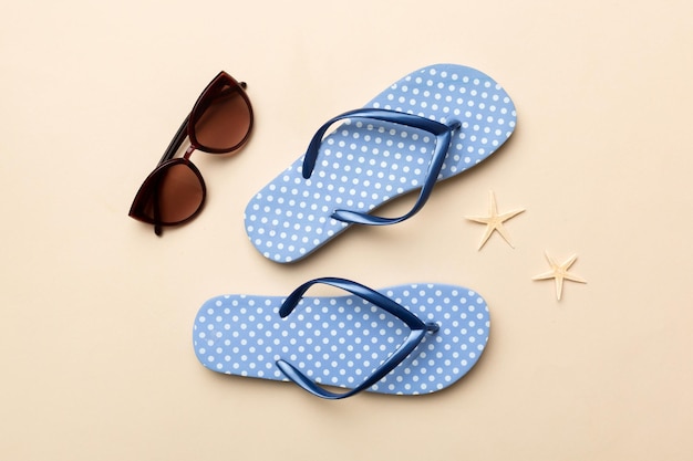 Summer travel concept Flip flops sunglasses and starfish on white Top view on colored background