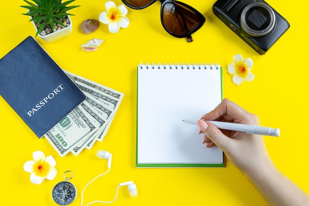 Summer travel planning Passport sunglasses camera and money on a yellow background