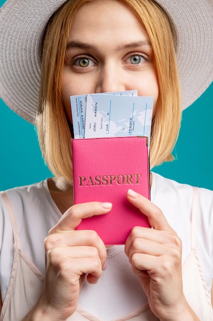 Summer trip Travel agency Happy woman in white holding foreign id with boarding pass Looking at camera isolated on blue Passport control Visa office