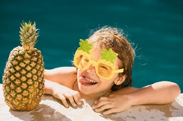 Summer vacation funny kid having fun in pool cute kid in swimming pool summer pineapple fruit funny