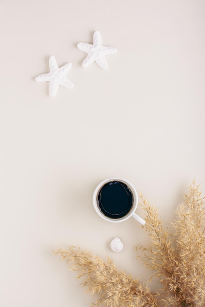 Summer vacation and relaxation concept starfish shells and a cup of coffee on a pastel vertical