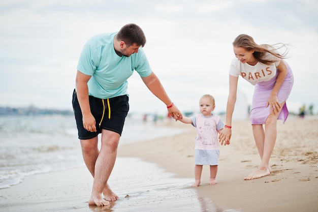 Summer vacations Parents and people outdoor activity with children Happy family holidays Father pregnant mother baby daughter on sea sand beach