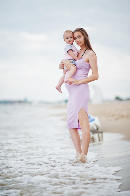 Summer vacations Parents and people outdoor activity with children Happy family holidays Pregnant mother with baby daughter on sea sand beach