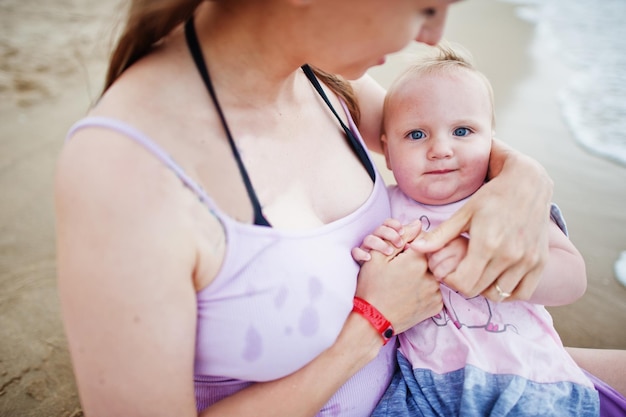 Summer vacations Parents and people outdoor activity with children Happy family holidays Pregnant mother with baby daughter on sea sand beach