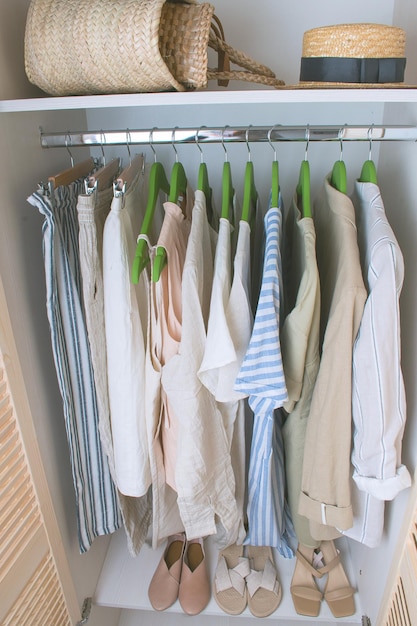 Summer wardrobe with linnen clothes on green hangers