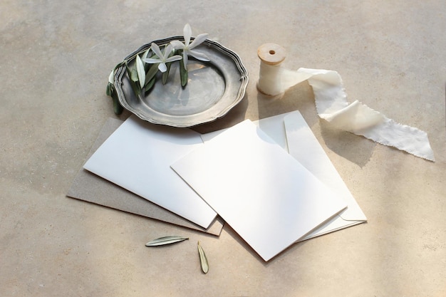 Summer wedding stationery mockup scene Blank greeting cards envelopes silver plate.