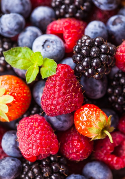 Summer wild berries as a background - raspberry, strawberry, blackberry and blueberry