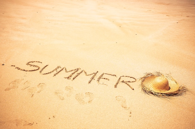 Summer word written on the sand on the beach