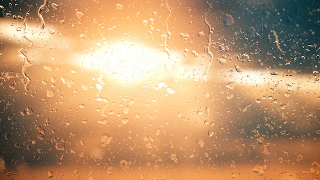 The sun in the clouds shines through the glass in the rain drops illustration