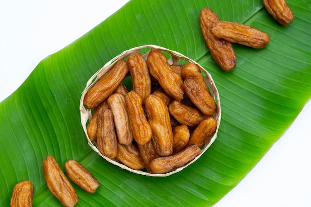 Sun-dried bananas in bamboo basket on banana leaf