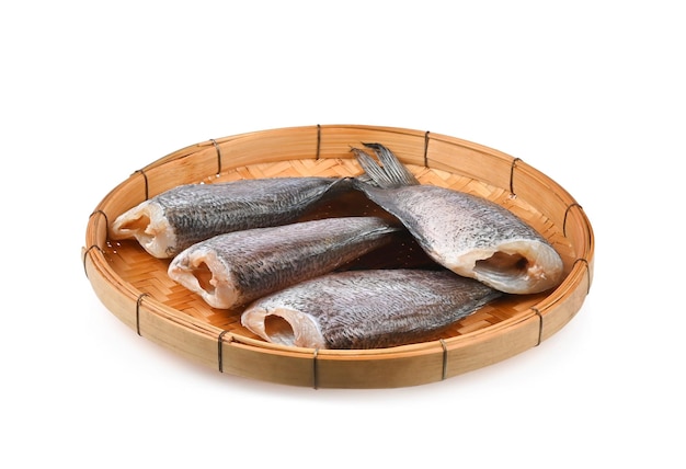 Sun dried fish in threshing basket isolated on white background