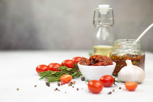 Sun dried tomatoes with fresh herbs spices tomatoes olive oil and garlik Grey background