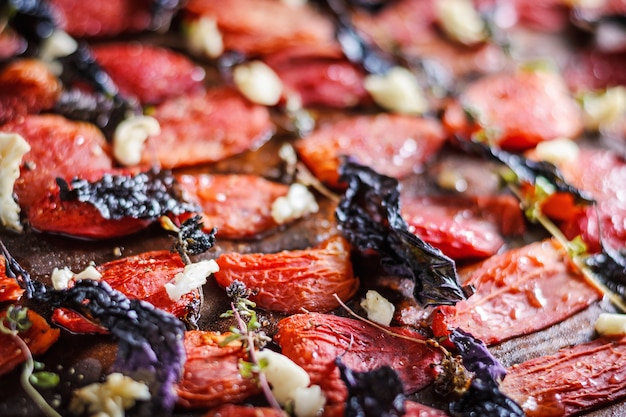 Sun-dried tomatoes with spices on baking sheet