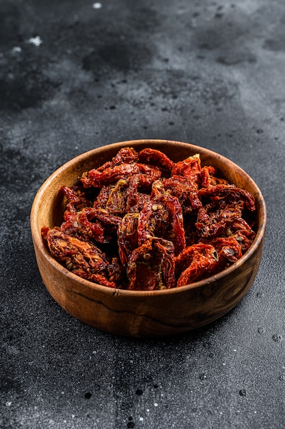 Sun dried tomatoes  in wooden bowl. Top view