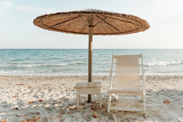 Sun lounger and umbrella on the sand with a sea view. Beach chair. Vacation, travel, rest, relaxation, nature concept