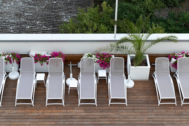 Sun loungers on wooden floor by the hotel swimming pool For relaxation and recreation at hotel resort