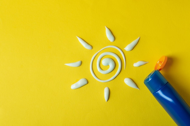 Sun made of sunscreen and bottle of cream on yellow