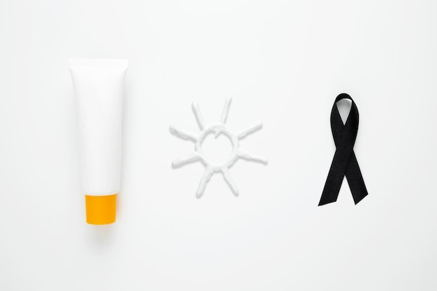 Sun protection Sunscreen and black ribbon symbol for fighting skin cancer Skin Cancer Awareness Month Concept Top view