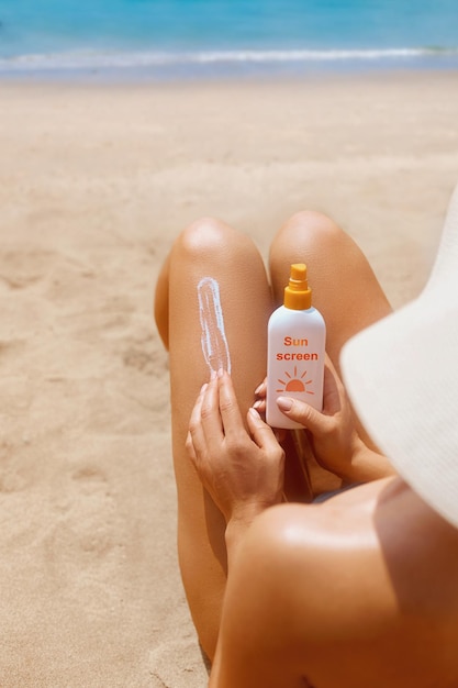 Sun protection Woman smear sunscreen moisturizing lotion on her smooth tanned legs