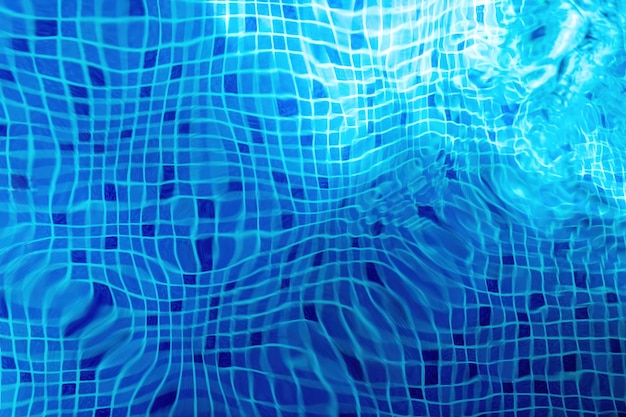 Sun reflection on the blue clear water ripples of pool with tile bottom Bottom of the pool water texture