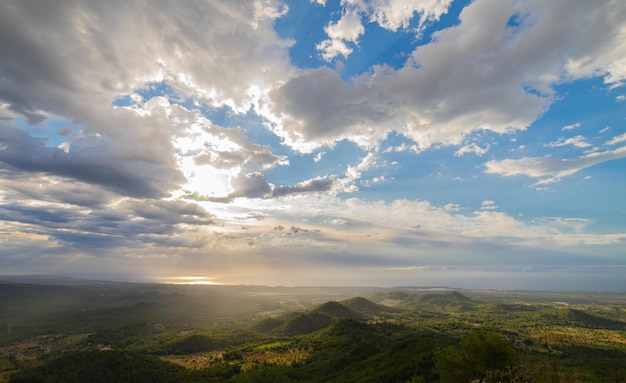 Sun rising from the sea seen from the mountains in between clouds