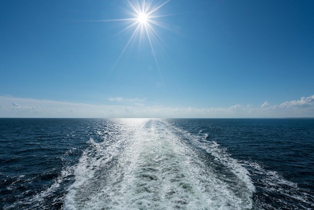 Sun shining over the wake of cruise ship at sea