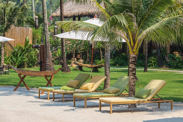 Sun umbrella and beach chairs on tropical coastline for holidays and relaxation Thailand Travel and nature concept