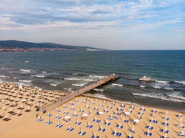 Sun umbrellas sunbeds on sand beach drone aerial view from above Sunny Beach in Bulgaria Summer holidays in Europe during quarantine