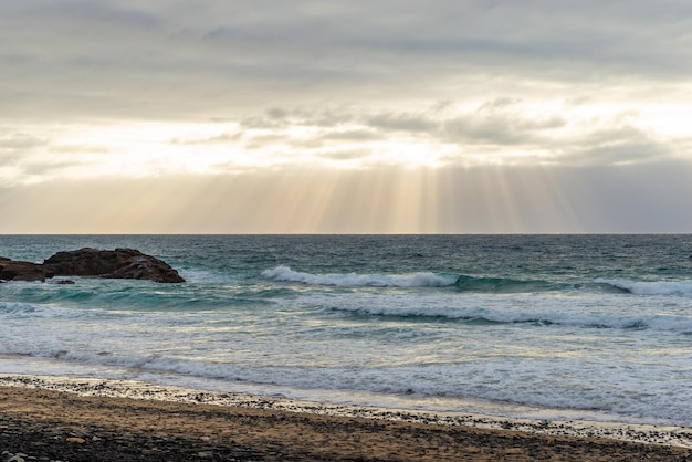 Sunbeams Breaking Through Clouds and Reflecting into the Ocean at Sunset Time on a Sealandscape