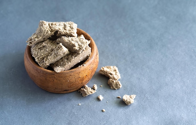 Sunflower halva in a clay plate on a gray background Made from sunflower seeds High quality photo