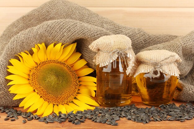 Sunflower oil and sunflower on wood background