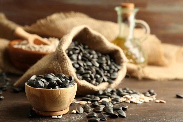 Sunflower seeds in bag on wooden table background closeup