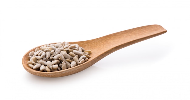 Sunflower seeds in wood spoon isolated on white background