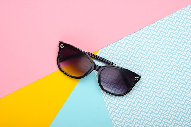 Sunglasses on a pastel colored background. Top view