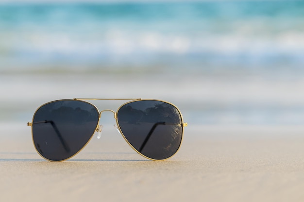 Sunglasses on sand beautiful summer beach  copy space Holiday concept.